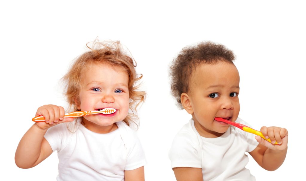 Toddlers brushing their teeth together.
